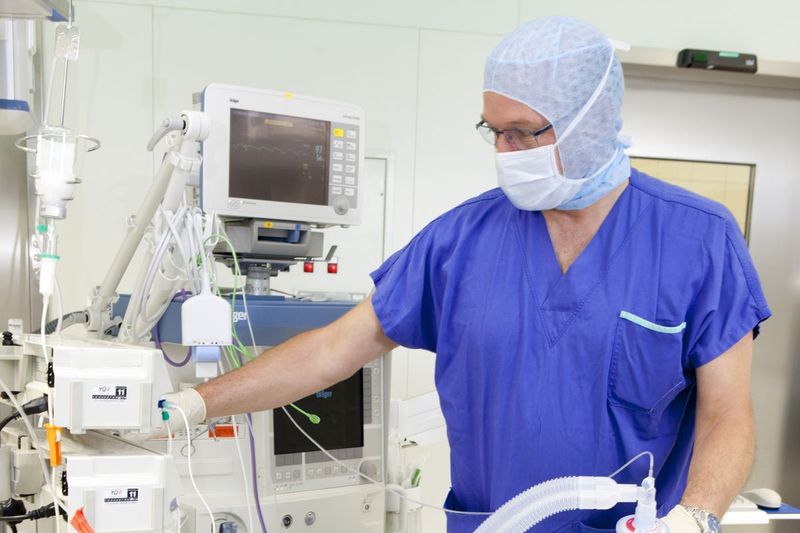 Anesthesiologist administering anesthesia to a patient in the operating room
